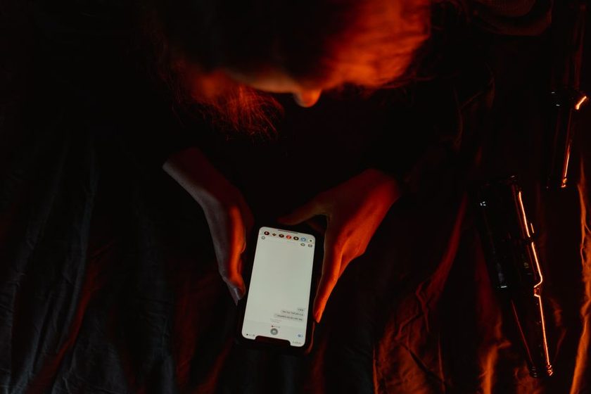A phone resting screen-down beside a notebook and a cup, quiet-hour symbolism