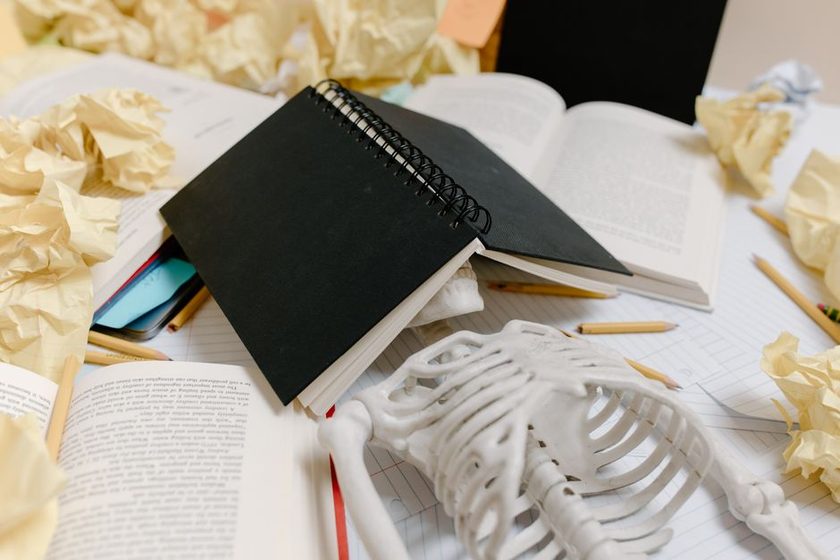 Overlapping papers on a desk suggesting several unfinished tasks