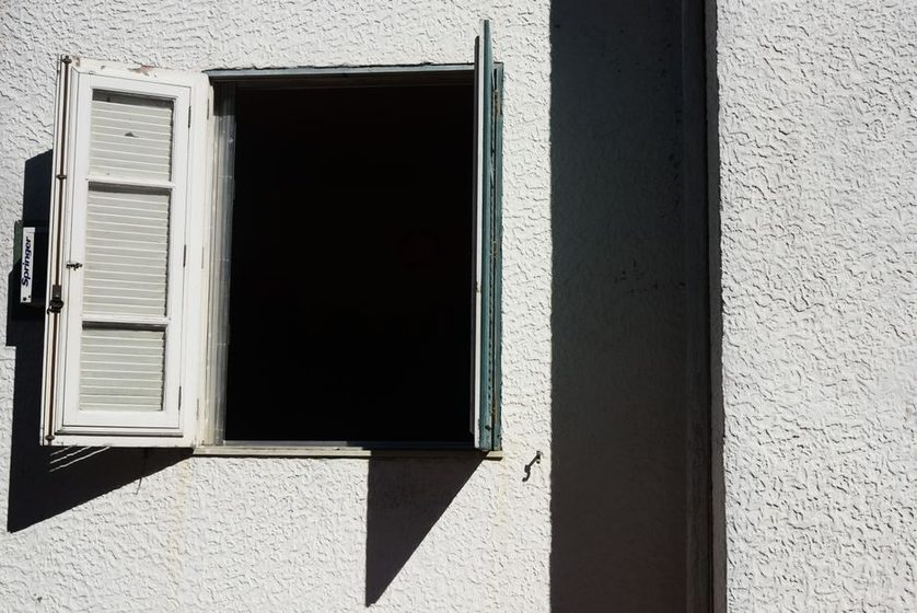 Someone stepping away from a desk to stretch by a window